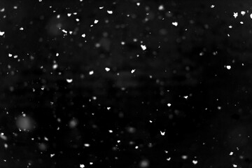 Texture of natural falling snow on black background.