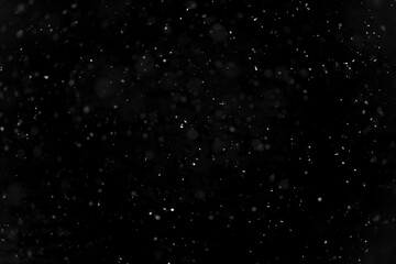 Texture of natural falling snow on black background.