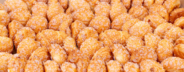 Puff pastries texture background, round sugar-coated sugar puffs pattern, golden crispy baked