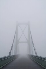 Suspension Bridge Fading into Thick Fog with a Sense of Mystery and Distance