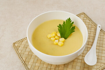 Creamy corn soup in ceramic bowl on the table. Vegetarian food
