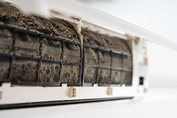 Dirty in dust and mold air conditioner filter close-up. Home air conditioner maintenance