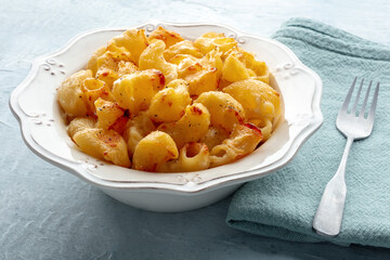 Mac and cheese, the classic pasta with macaroni and Cheddar cheese, baked in the oven, with a fork