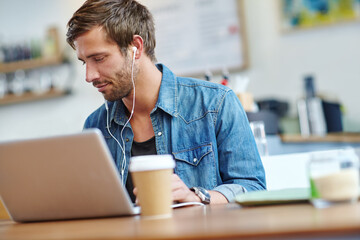 Man, laptop and writer with earphones in cafe, research and article for internet blog in bistro....