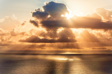 cloud in a form of flying sauser with light and shadows in amazing sunrise or sunset sky above water in beautisul seascape