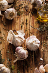 Garlic bulbs and thyme on  a wooden board, top view