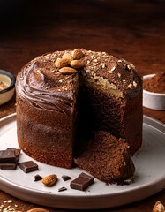 G&acirc;teau moelleux au chocolat avec gla&ccedil;age fondant, &eacute;clats d&rsquo;amandes et copeaux de chocolat sur une assiette grise