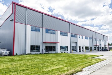 Fototapeta premium Modern industrial building with large windows and red accents.