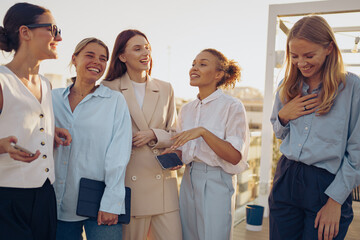 A group of fashionable and stylish women have gathered outside to enjoy a joyful moment together