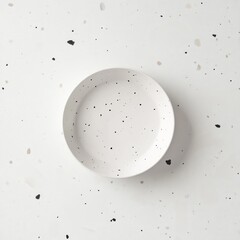 Round, white dinner plate with speckles of beige and black