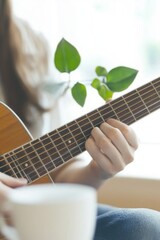 Fototapeta premium Person playing acoustic guitar in cozy living room creating a warm and relaxing musical atmosphere.