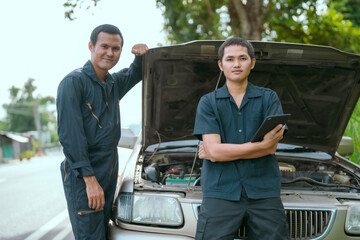 Skilled mechanics provide automotive repair services on a quiet roadside in the afternoon sunlight