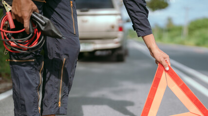 Obraz premium Roadside assistance with warning triangle on a rural road during the day