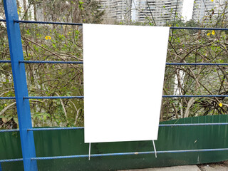 Blank white mockup template of a billboard on the fence. Background texture of empty advertising...
