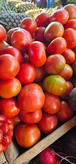 Pile of tomatoes at an outdoor market.
