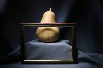 Still life with a pumpkin on a gray background and a photo frame