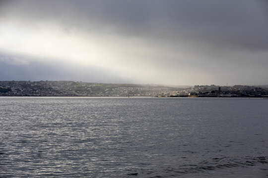 Penzance (and Newlyn) in Cornwall, UK - lit by a ray of sunshine through the clouds and looking like a painting.