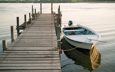 Naklejka premium Mississippi River, Wooden Dock and Boat at River Sunset
