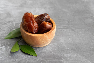 Delicious kurma in a small wooden bowl. Popular during Ramadan as an Iftar Food.