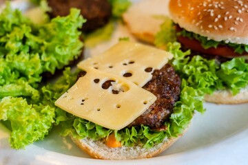 Close up view on preparing cheeseburger with vegetables and meat