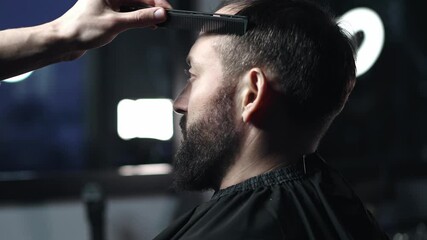 Skilled barber grooming client's hair with precision, working inside contemporary barbershop setting, preparing stylish haircut