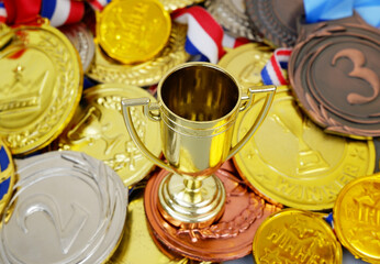 Gold champion cup and many medals close up