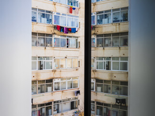 Colorful laundry hanging between buildings in a Barcelona courtyard during a sunny day