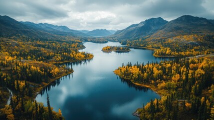Fototapeta premium Aerial view of a diverse landscape featuring a winding river flowing through a mix of green and autumn-colored trees.