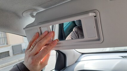 Hand holding Car sun visor.
