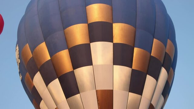 Tilt Handheld Blue Gold Hot Air Balloon on Sky Background. Funny Balloon Festival Activity