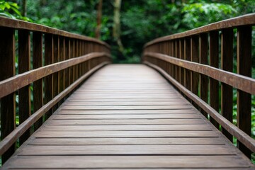Obraz premium A wooden bridge stretches through lush green foliage, inviting exploration in a serene, natural setting.