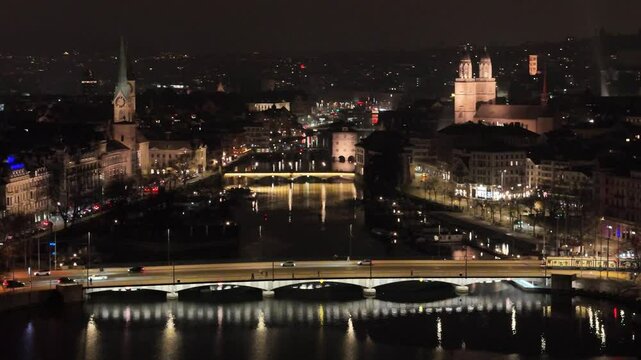 nighttime zurich historic town center trams river bridges also includes churches university eth close up aerial panning shot view switzerland night drone swiss banking charm 