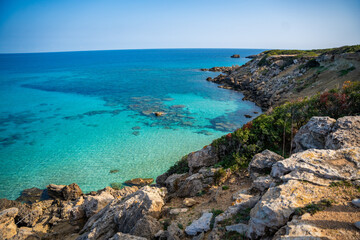 Coastline with a sandy beach and rocky shores near the northeasternmost cape of Northern Cyprus. Crystal-clear waters of a blue lagoon and the untouched beauty of the Mediterranean