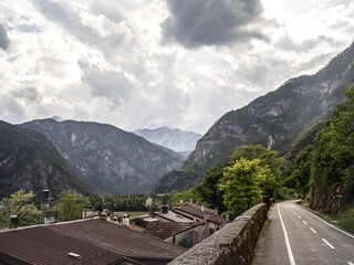 A winding road along the Alpe Adria cycling route in Italy, offering breathtaking views of rugged...