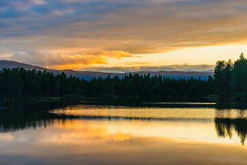 Exploring the serene landscape of Sweden at sunset with golden reflections on a calm lake