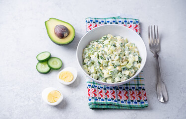 Egg cucumber avocado salad with mayonnaise sauce in a bowl