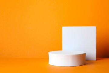 White podiums with pumpkin on two tone background