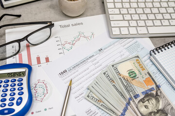 1040 us Tax forms, pen calculator and dollar money glasses on the table. Taxation, paying the tax rate. April time