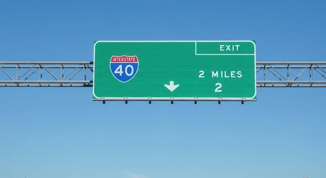 Interstate 40 Exit Sign Displaying Two Miles Ahead Under Blue Sky
