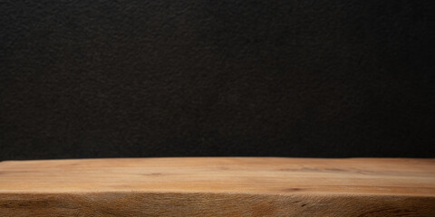 Rustic wooden table on black background for product display, food photography, or text overlay..