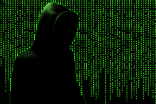 hooded hacker on green binary code background