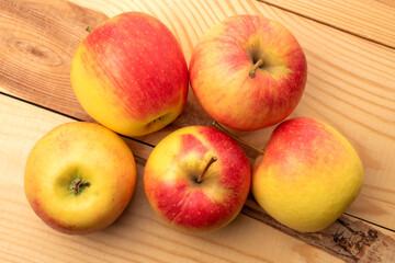 Several juicy apples on a wooden table, close-up, top view.