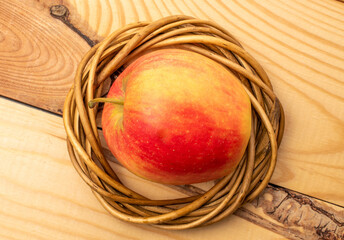 One juicy apple on a wooden table, close-up, top view.