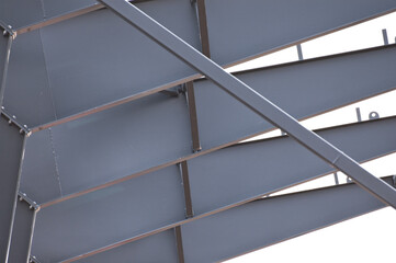 Metal construction, in the photo the structure of the building frame made of metal beams against the background of a gray sky