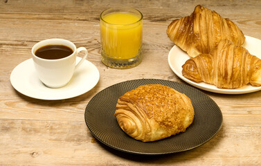Petit déjeuner complet avec café, jus d'orange et un pain au chocolat