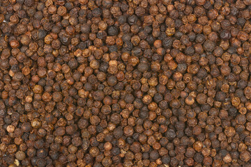A close-up, full-frame shot of dried black peppercorns, showcasing their texture and color