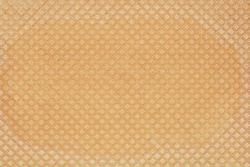 A close-up, full-frame shot of a wafer sheet texture, highlighting its detailed diamond pattern and light brown color
