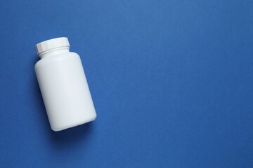 White bottle on blue background, top view