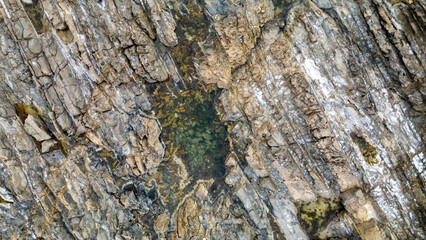 A rocky bay in Australia covered in orange lichen, seen from above