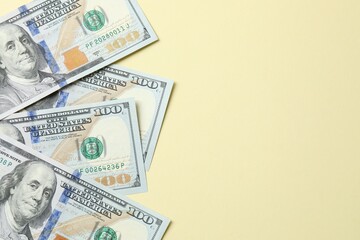 Money, one hundred US dollar bills on a beige texture. Money is scattered on the table. Finance and economics concepts. Saving money concept